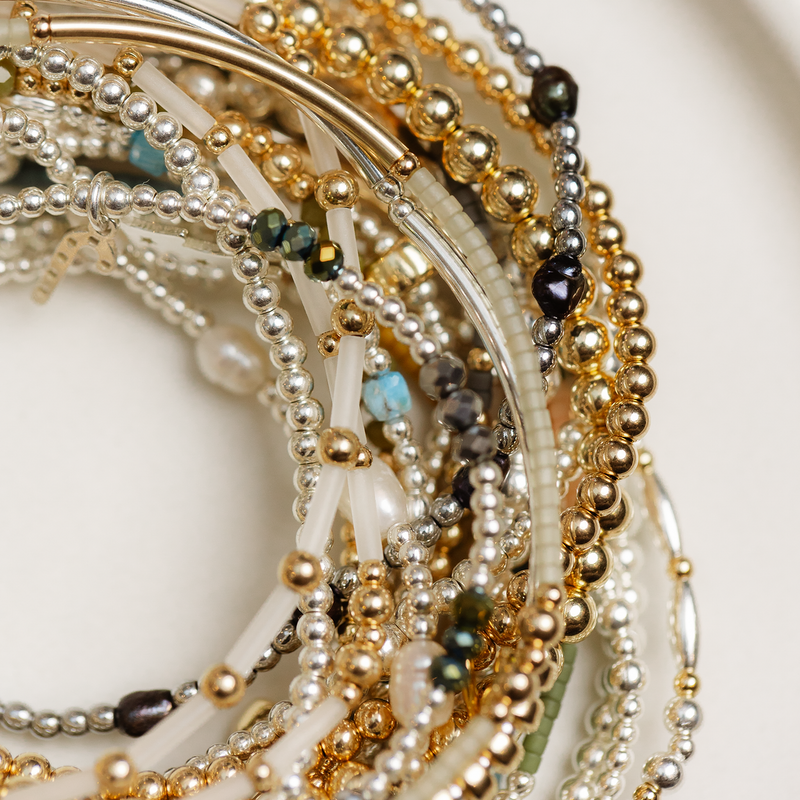 Close-up of multiple beaded bracelets on a white plate